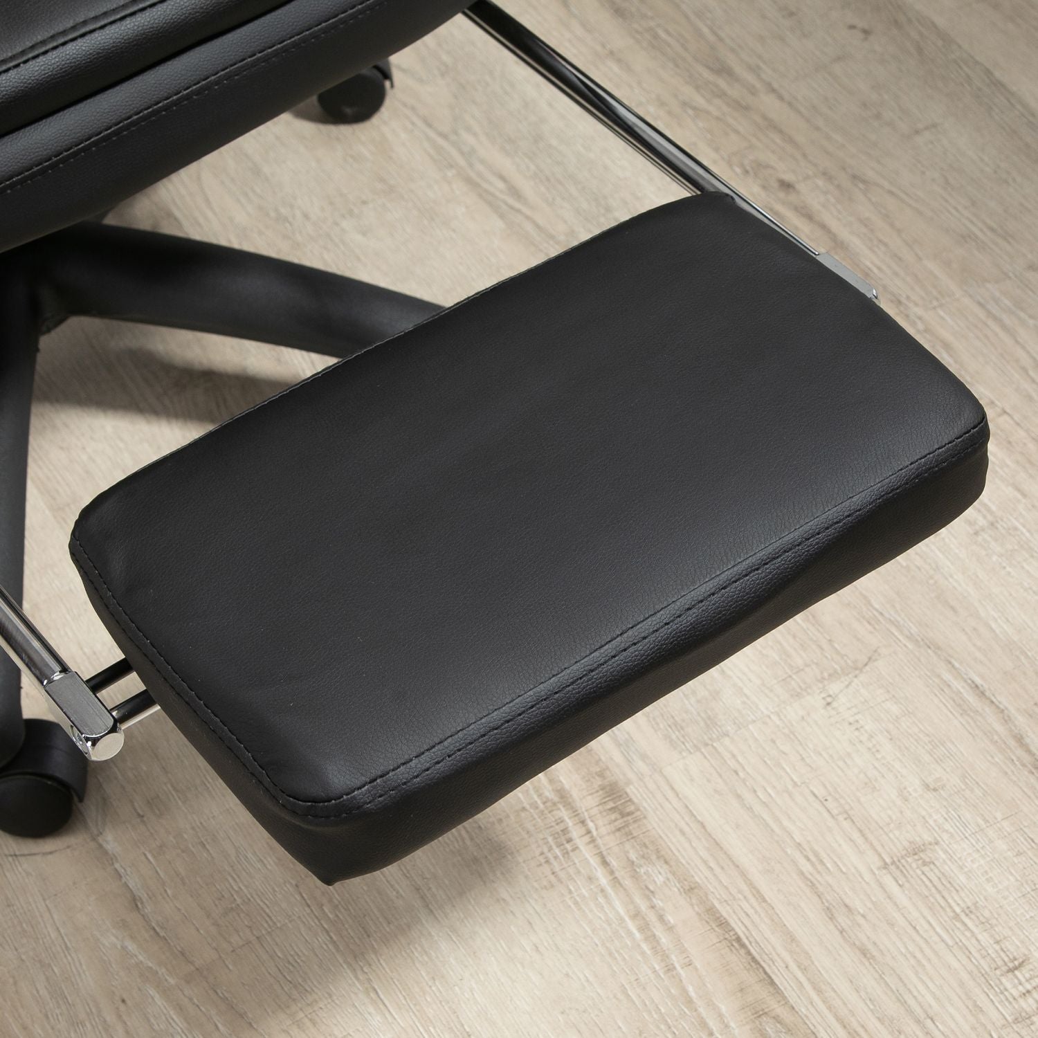 Ergonomisk svart kontorsstol med fotstöd, vadderat ryggstöd